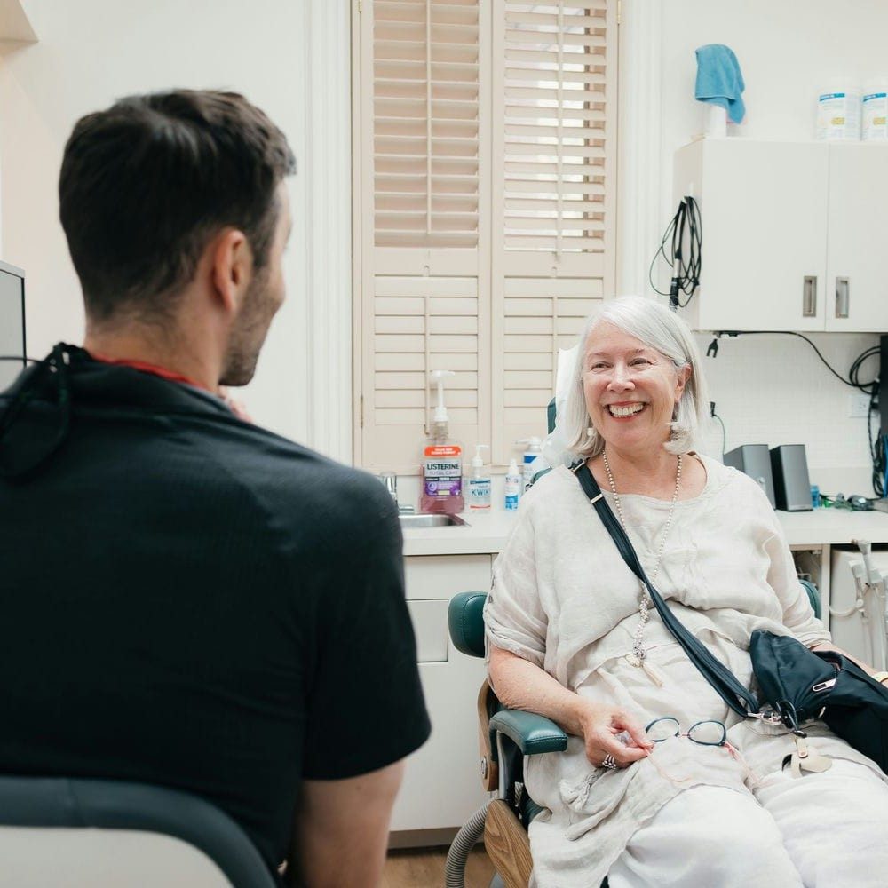 Markham dentist and patient talking through tooth replacement options with X-rays on screen