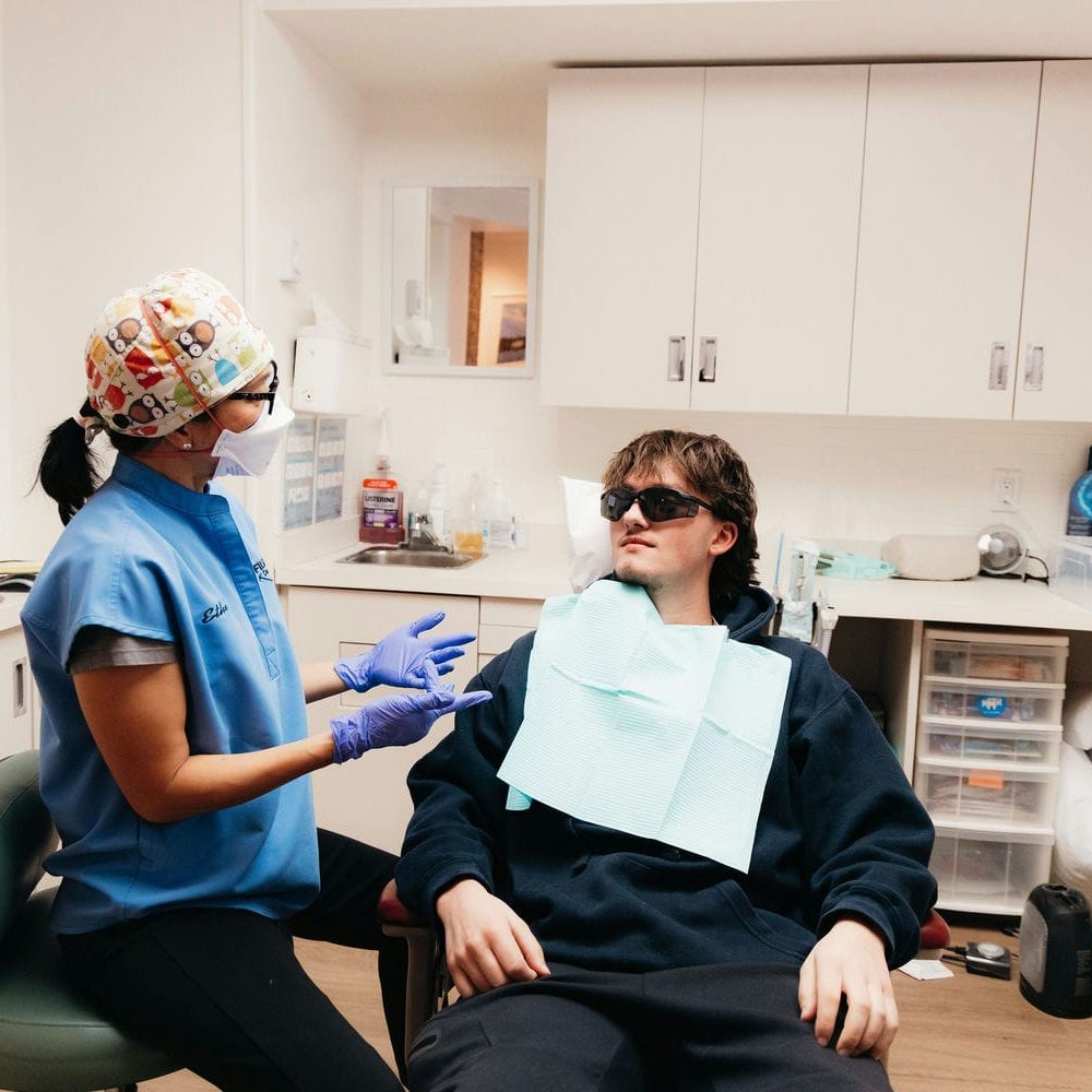 Markham dental team member explaining the wisdom tooth removal process to a young patient